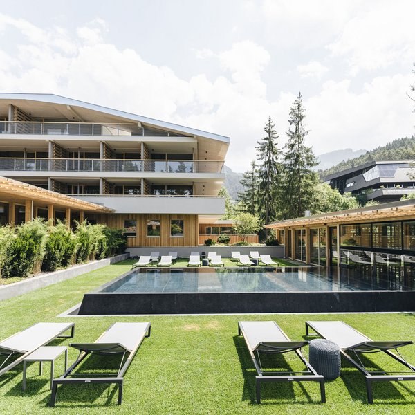 Sensoria Soulmates – Creating Memories of Bliss Modern pool area with lounge chairs and building in alpine setting