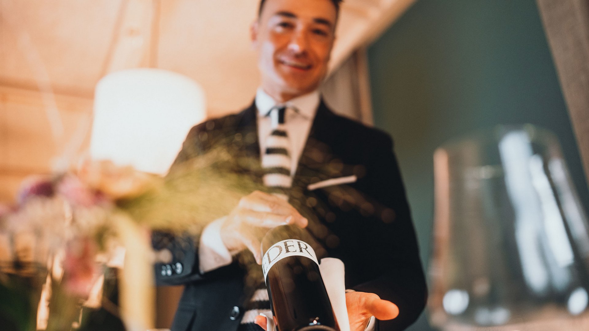 Posizioni aperte Cameriere serve una bottiglia di vino in un ambiente elegante