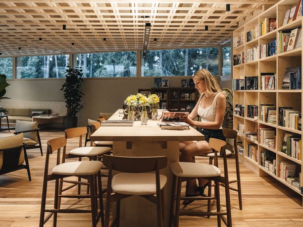 Sensoria Soulmates – Creating Memories of Bliss Woman reading a book at a wooden table in a modern cozy reading room with bookshelves