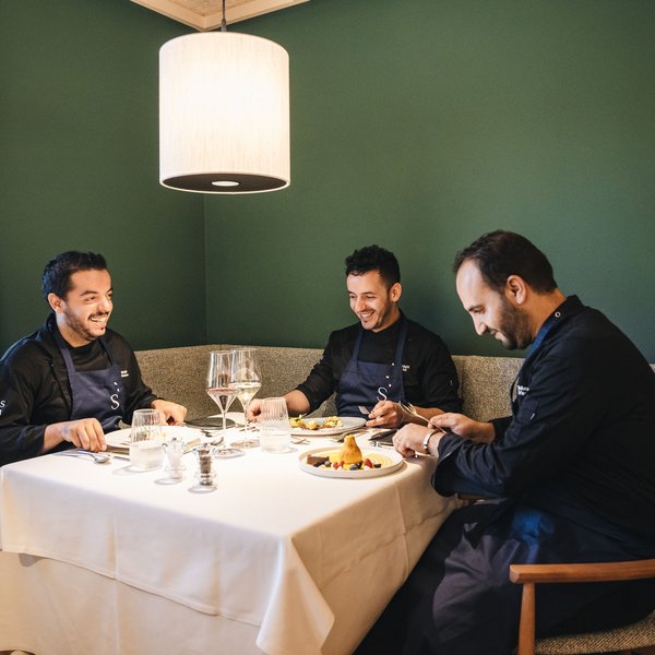 Sensoria Soulmates – Creating Memories of Bliss Three chefs enjoying a meal at a set table in a cozy room