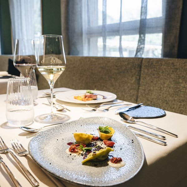 Sensoria Soulmates – Creating Memories of Bliss Elegant restaurant table with gourmet dish and wine glasses on white tablecloth