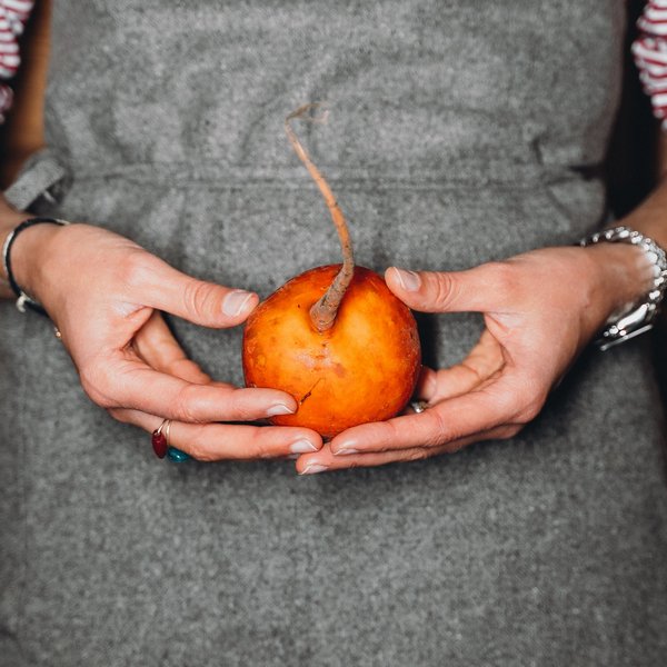 Sensoria Soulmates – Creating Memories of Bliss Person holding a yellow beet with a long stem in both hands