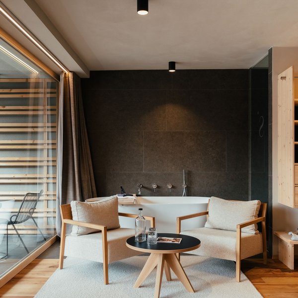 Sensoria Soulmates – Creating Memories of Bliss Modern living room with light armchairs, round table, and bathtub