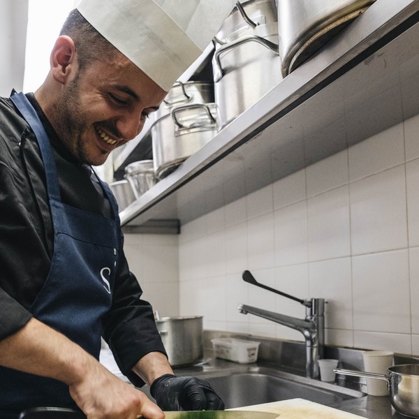 Sensoria Soulmates – Creating Memories of Bliss Smiling chef chopping fresh herbs in professional kitchen