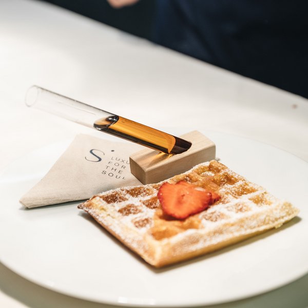 Sensoria Soulmates – Creating Memories of Bliss Waffle with strawberry and powdered sugar on plate with test tube and napkin