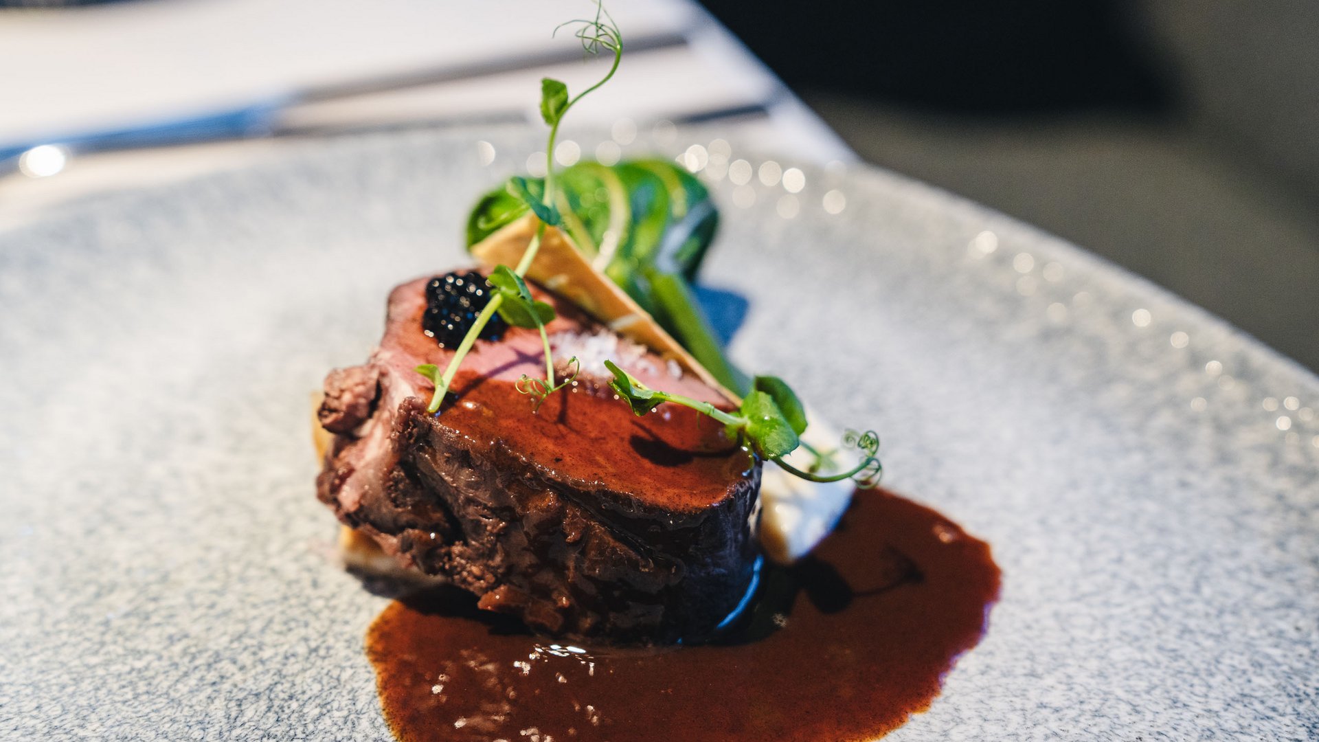 Posizioni aperte Bistecca raffinata con salsa e erbe su piatto grigio