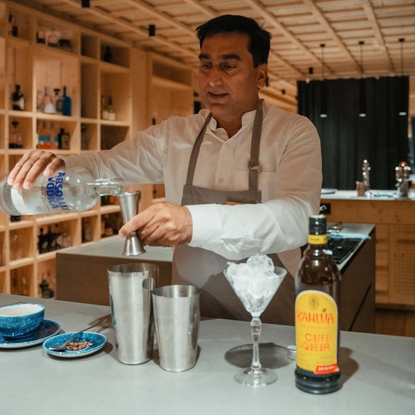 Sensoria Soulmates – Creating Memories of Bliss Bartender measuring Absolut vodka in bar with spirits and ice